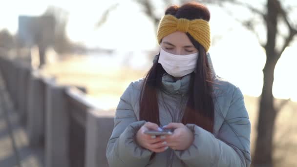 Fiatal nő maszkot visel sms-ezés a Smartphone - Felvétel, videó
