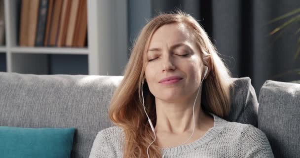 Relaxed woman listening music on earphones - Materiaali, video