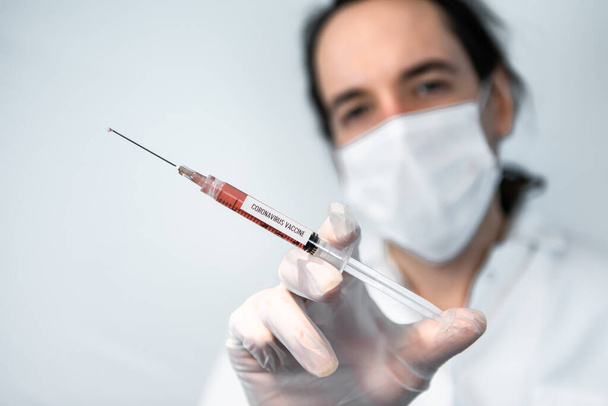 Technik laboratoryjny posiada szczepionkę przeciwko koronawirusowi. - Zdjęcie, obraz