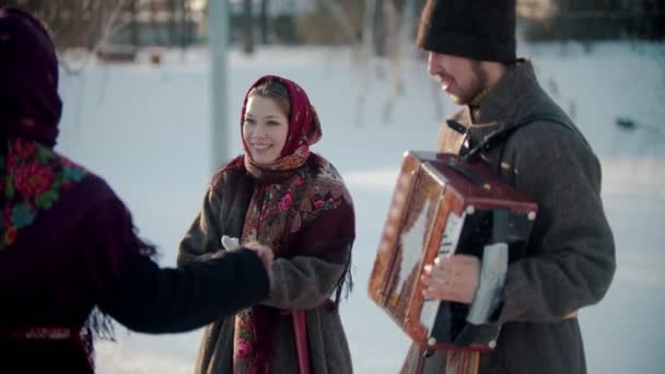 Russian traditions - a beautiful woman in traditional clothes is dancing merrily to the music of the accordion - Footage, Video