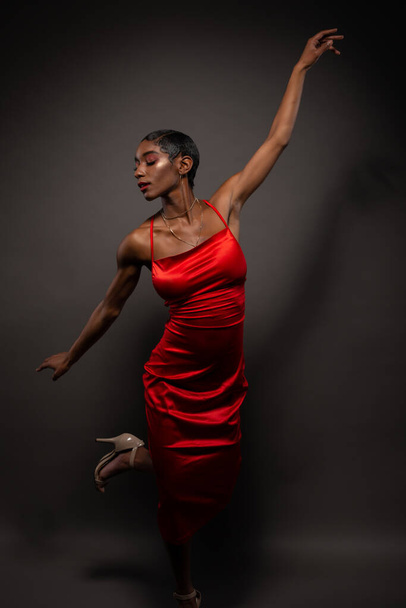 Slender young African American woman in a tight red dress - Foto, afbeelding