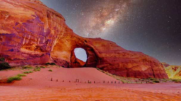 Starry Sky πίσω από το Αυτί του Ανέμου, μια τρύπα σε ένα σχηματισμό βράχου στο Monument Valley Navajo Tribal Park στα σύνορα της Γιούτα και της Αριζόνα, Ηνωμένες Πολιτείες - Φωτογραφία, εικόνα