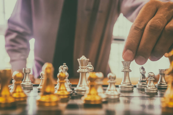 Σκάκι παιχνίδι στην σκακιέρα πίσω από το φόντο του επιχειρηματία. Επιχειρηματική ιδέα για την παρουσίαση χρηματοοικονομικών πληροφοριών και ανάλυση στρατηγικής μάρκετινγκ. Επενδυτικός στόχος στην παγκόσμια οικονομία και στο ψηφιακό εμπόριο. - Φωτογραφία, εικόνα