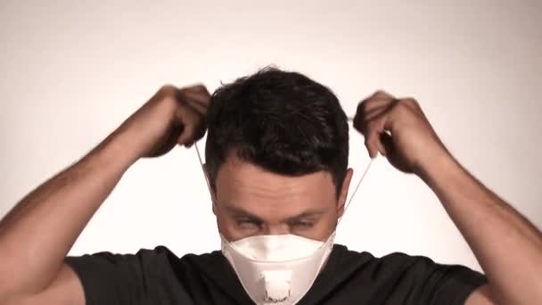 Person isoliert auf weiß im Studio zieht Beatmungsgerät an und entfernt es, um frische Luft zu atmen. - Filmmaterial, Video