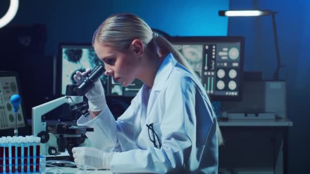 Επιστήμονας που δουλεύει στο εργαστήριο. Γυναίκα γιατρός που κάνει ιατρική έρευνα. Εργαστηριακά εργαλεία: μικροσκόπιο, δοκιμαστικοί σωλήνες, εξοπλισμός. Coronavirus 2019-ncov, βιοτεχνολογία, επιστήμη, πειράματα και έννοια της υγειονομικής περίθαλψης. - Πλάνα, βίντεο
