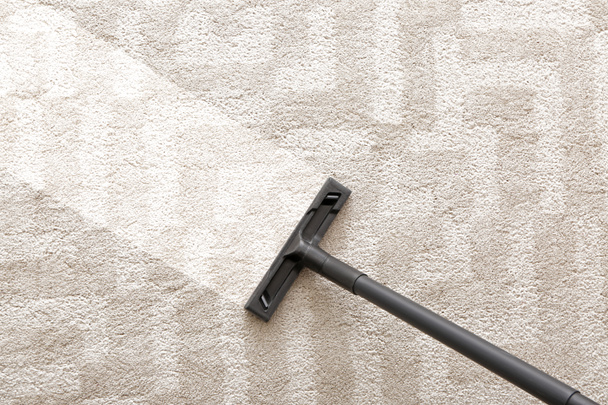 Opzuigen van tapijt met stofzuiger, bovenaanzicht - Foto, afbeelding
