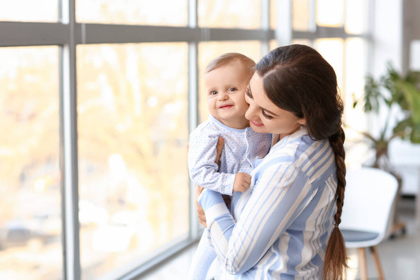 Boldog anya aranyos kis baba mellett ablak - Fotó, kép