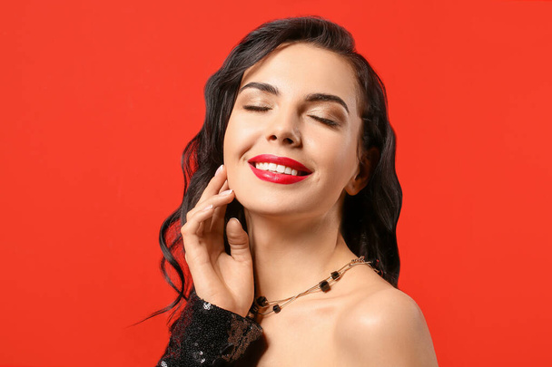 Mladá žena s krásným make-up na barevném pozadí - Fotografie, Obrázek