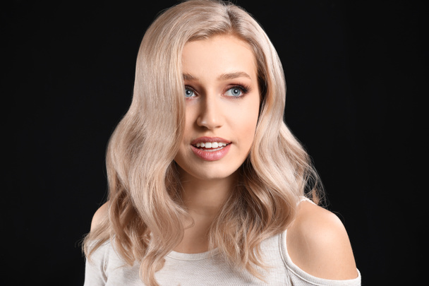 Fiatal szőke gyönyörű haj sötét háttér - Fotó, kép
