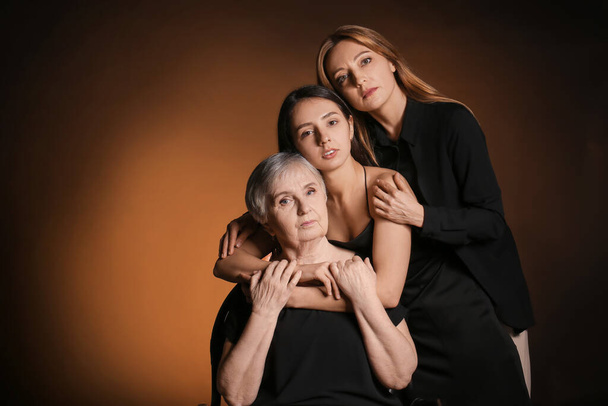 Portrait of mature woman with her adult daughter and mother on dark color background - Zdjęcie, obraz