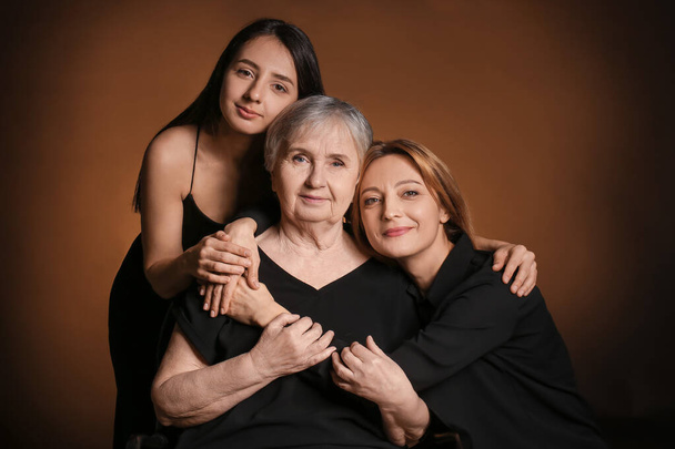 Portrét dospělé ženy se svou dospělou dcerou a matkou na tmavém pozadí - Fotografie, Obrázek