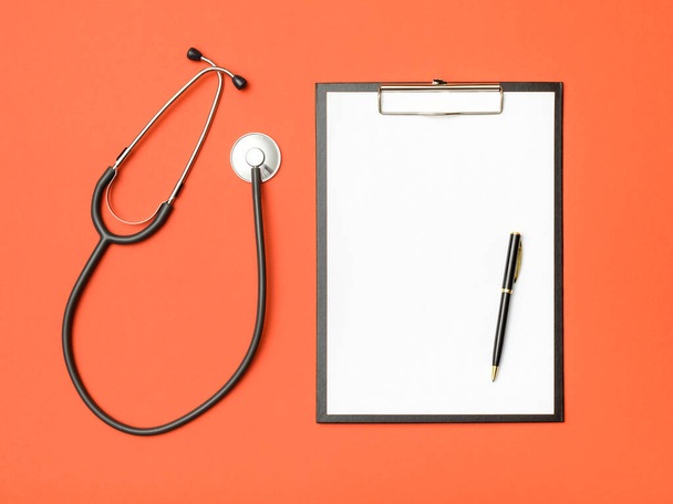 Draufsicht auf den Schreibtisch des Arztes. Stethoskop und Notizbuch auf farbigem Hintergrund. Medizinkonzept - Foto, Bild