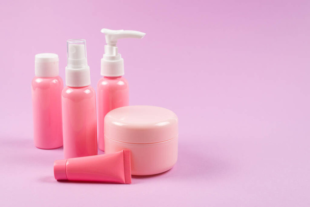 Roze plastic flessen voor hygiëneproducten, cosmetica, hygiëneproducten op een roze achtergrond. Kopieerruimte.  - Foto, afbeelding