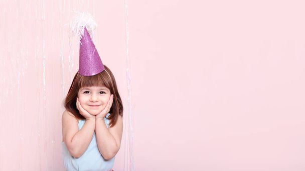 celebration concept. Kid girl dressed festive,party clothes on a pink background - 写真・画像