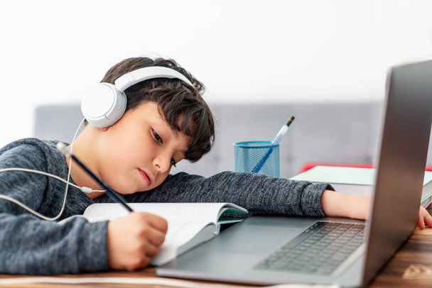 Little boy is studying in front of the laptop. E learning, study at home online. - Φωτογραφία, εικόνα