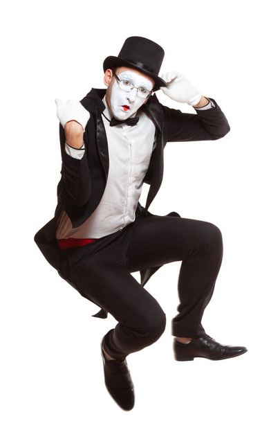 Portrait of a male mime artist performing, isolated on white background. Symbol of unpleasantly surprised, upset, falling, squatting, sad - Foto, afbeelding