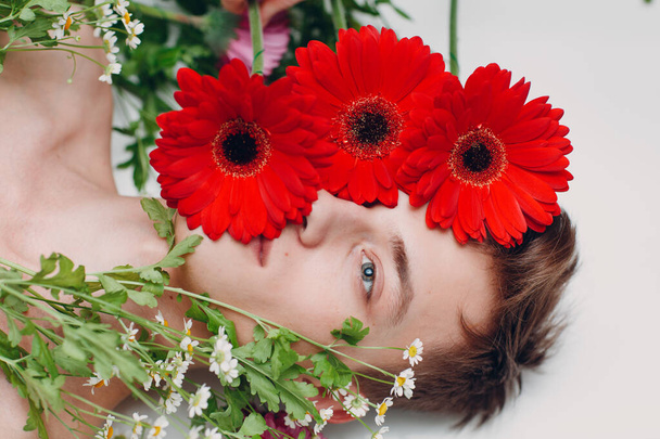 Young male model with flowers. Beauty portrait. - Valokuva, kuva