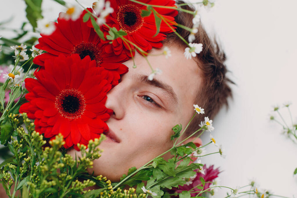Young male model with flowers. Beauty portrait. - Zdjęcie, obraz