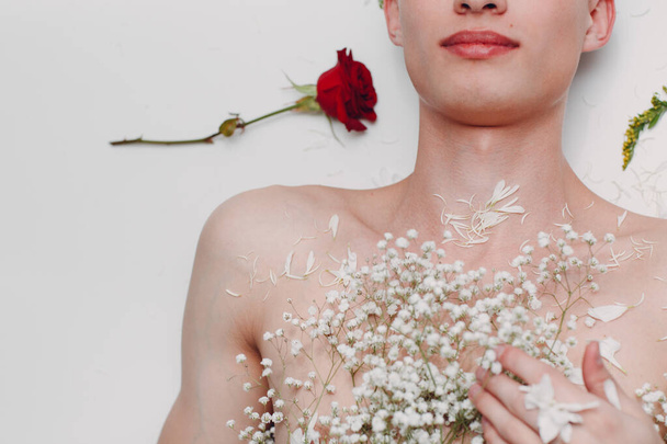 Jeune mannequin masculin avec des fleurs. Portrait beauté
. - Photo, image