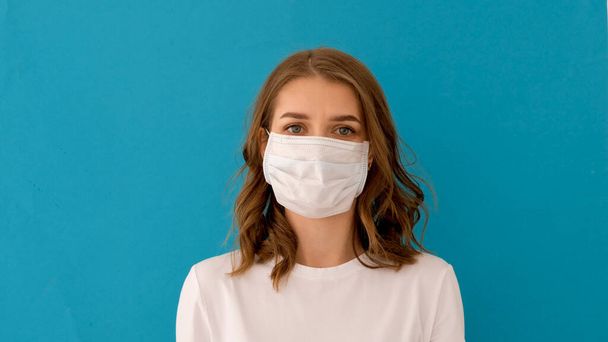 женщина надевает хирургическую маску для профилактики коронного вируса - Фото, изображение