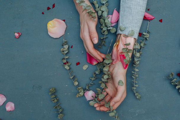 Hands, flowers, petals on the table - Фото, зображення