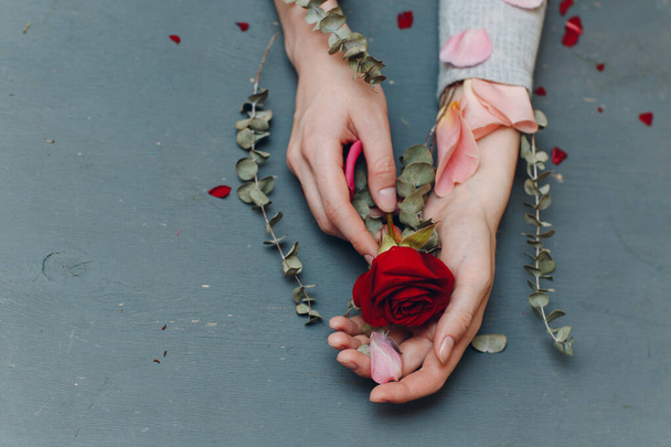 Hands, flowers, petals on the table - Φωτογραφία, εικόνα