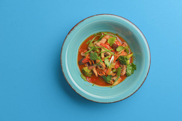 Mixed vegetable seafood salad. Served in a blue bowl over bright blue background. Heathy tasty dinner. - Foto, Imagen
