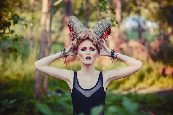 Sexy beautiful woman with horns. Hairstyle. Fantasy girl in woods - Foto, Imagen