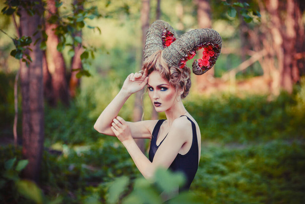 Sexy beautiful woman with horns. Hairstyle. Fantasy girl in woods - Valokuva, kuva