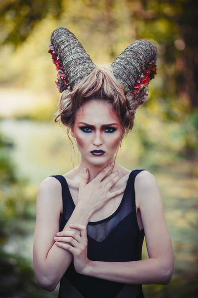 Sexy beautiful woman with horns. Hairstyle. Fantasy girl in woods - Фото, зображення