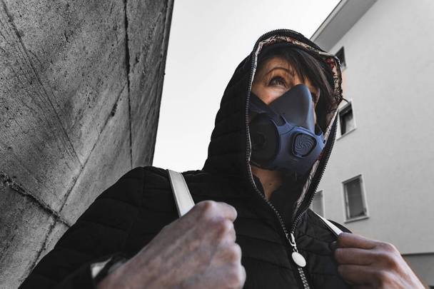 femme avec un masque à gaz marchant dans les rues de la ville survivant à une pandémie de virus corona ou un monde post-atomique
 - Photo, image