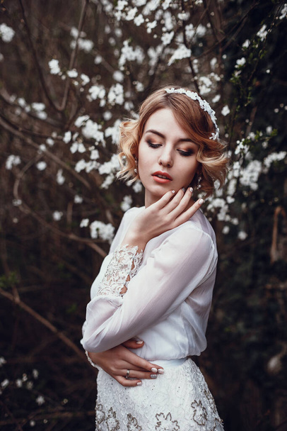 Jeune belle femme blonde dans le jardin fleuri. Mariée. début du printemps
 - Photo, image