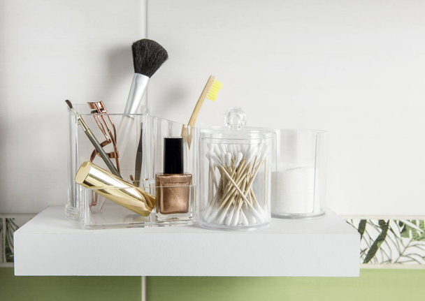Make up products organizing concept. Beauty products in organizer container box on tidy way on minimalist shelf. Cotton pads stacked, Q-tips and make up brushes. - Photo, Image