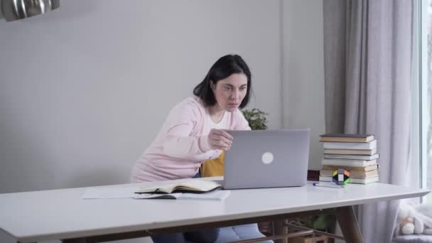 Portrait of adult Caucasian woman opening laptop and looking at screen with surprised face. Young brunette lady spying after relatives indoors. Secret, privacy, reliance, lifestyle. - Materiał filmowy, wideo