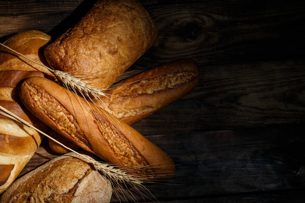 Diferentes pães cozidos com farinha e trigo sem glúten em uma mesa de madeira - Foto, Imagem