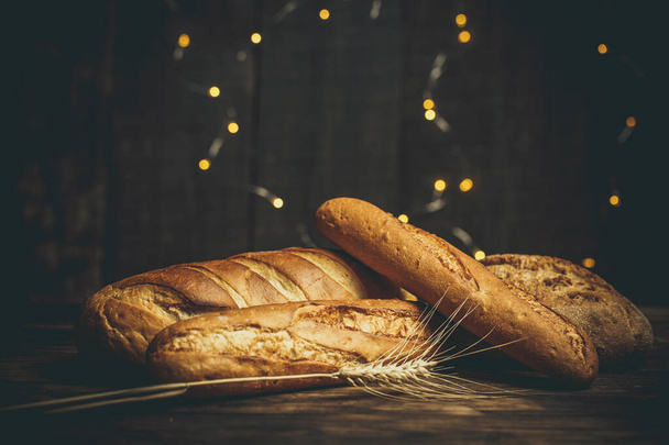 Différents pains cuits avec de la farine et du blé sans gluten sur une table en bois - Photo, image