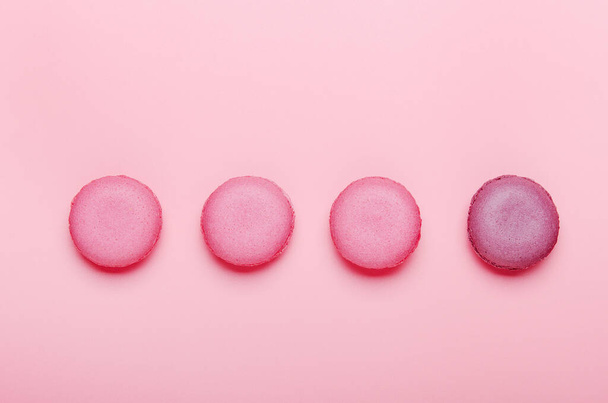 Pink macaroon cookies on a pink background. The concept of sweets, pastries, junk food. Minimal composition. Top view, flat lay. - Zdjęcie, obraz