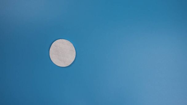 New cotton pad for removing makeup on a blue background with place for text - Photo, Image