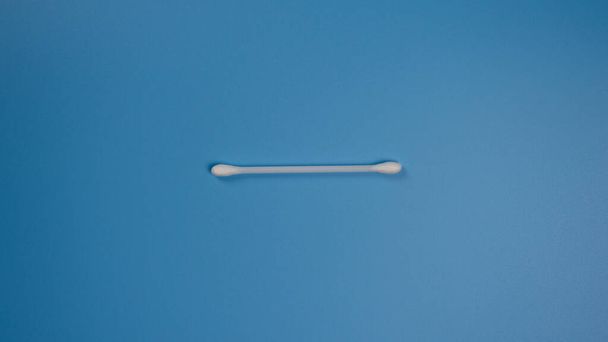 Nuevo bastón para extraer azufre de las orejas sobre un fondo azul con lugar para texto. Plano-lay
 - Foto, Imagen