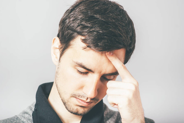 man with headache in photo studio background - Foto, Imagen