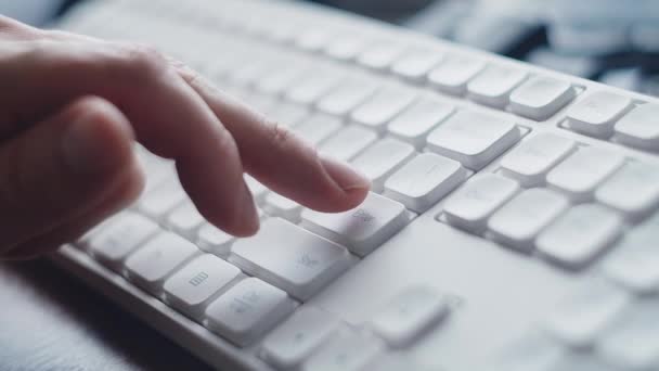Der menschliche Finger drückt wiederholt die Enter-Taste auf einer weißen Tastatur. Eingabetaste. - Filmmaterial, Video