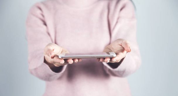 woman hand holding smart phone on gray background - Photo, image