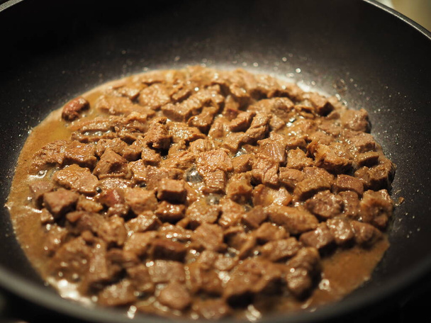 Goulash de carne de filé de frango e cebola com temperos fritar em uma panela no fogão. Delicioso prato simples close-up
 - Foto, Imagem