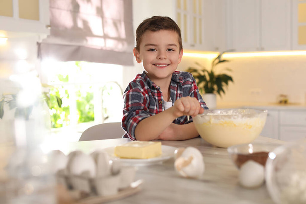 Χαριτωμένο μικρό αγόρι μαγείρεμα ζύμη στην κουζίνα στο σπίτι - Φωτογραφία, εικόνα