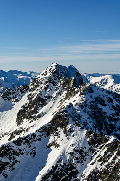 Vista do pico excepcional no Alto Tatras localizado na fronteira polaco-eslovaca - Swinica (Svinica). Turistas e montanhistas visíveis nos topos. Paisagem inverno
. - Foto, Imagem
