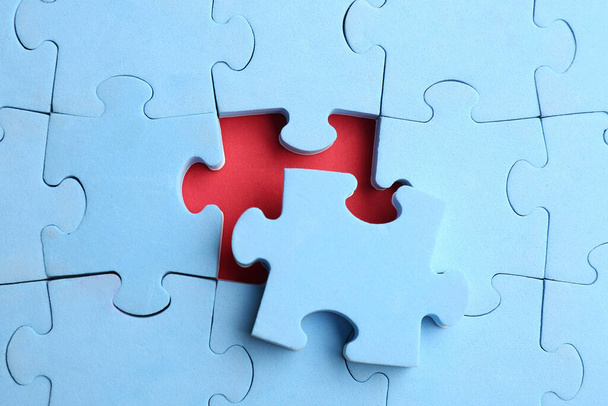 Light blue puzzle on red background, top view. Career promotion concept - Φωτογραφία, εικόνα