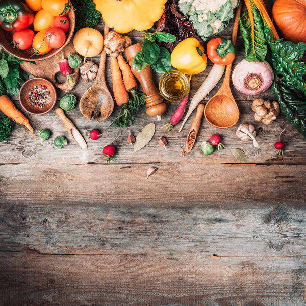 Organic food. Harvest of fresh vegetables on wooden background. Top view. Copy space. Diet or vegetarian food concept. Assortment of churd, pumpkin, carrot, pepper, cabbage, garlic, tomatoes. - Photo, Image