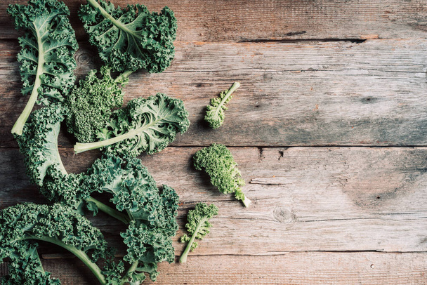 Fresh green curly kale on wooden background. Top view, copy space. Zero waste, organic vegetables concept. Vegan and vegetarian diet food. - Фото, зображення
