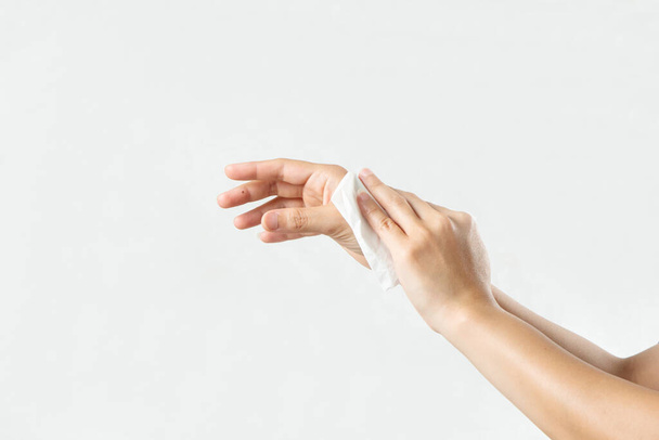 Γυναίκα καθαρίζει τα χέρια της με λευκό μαλακό χαρτί. απομονώνονται σε λευκό φόντο - Φωτογραφία, εικόνα