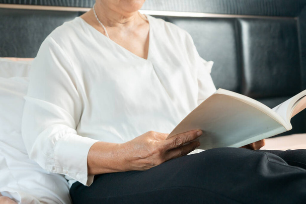 Covid-19 atividade de quarentena para a mulher idosa ler um livro ficar em casa para evitar o risco
 - Foto, Imagem